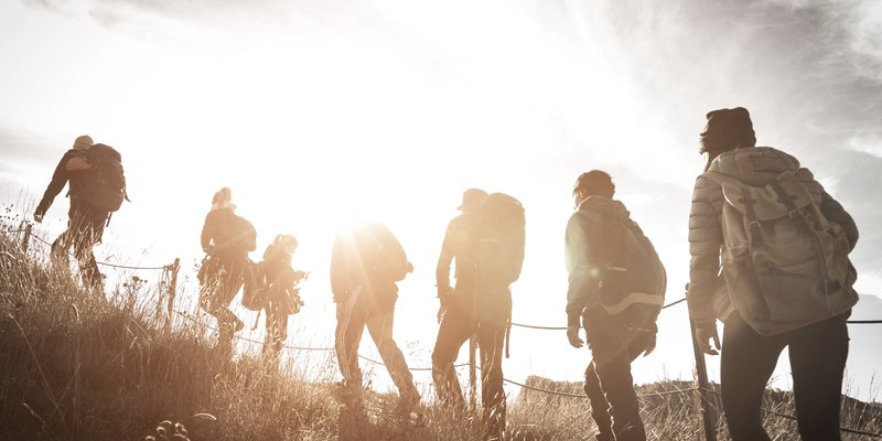 group-of-hikers-walking-on-a-mountain-at-sunset-2023-11-27-05-29-06-utc-min